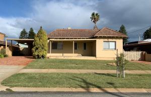 a house with a palm tree in the yard at Ocean Vista Beach Stay in Rockingham