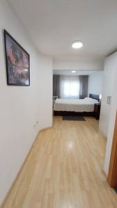 1 dormitorio con 1 cama y suelo de madera en Sweet Home, en Esplugues de Llobregat