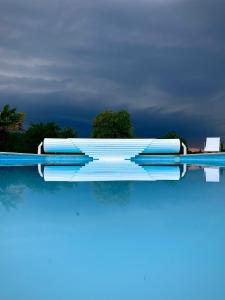 a pool with blue and white rafts on the water at Roc du Lapin in Sainte-Colombe-de-Villeneuve