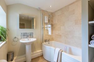 a bathroom with a bath tub and a sink and a bath tub at Bell Cottage - Pretty Period Cottage DOG FRIENDLY in Northallerton