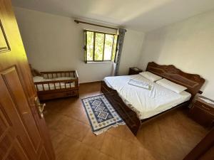 a small bedroom with a bed and a window at Sibora Guest House Liqeni Ulez in Kokërdhok