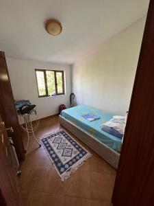 1 dormitorio con cama, mesa y ventana en Sibora Guest House Liqeni Ulez, 