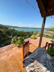 a patio with a table and chairs and a view of the water at Sibora Guest House Liqeni Ulez in Kokërdhok