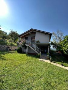Casa pequeña con porche y patio de hierba en Sibora Guest House Liqeni Ulez, 
