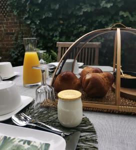 une table avec une assiette de nourriture et un panier de pain dans l'établissement La Maison de Ville, à Compiègne