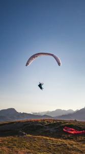 uma pessoa a voar de pára-quedas sobre um campo em L'Oxalys Studio ! Coin montagne - Pied des pistes & Centre ville em Briançon