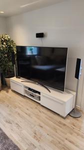 a large flat screen tv sitting on a white entertainment center at Tift bossgård in Linköping