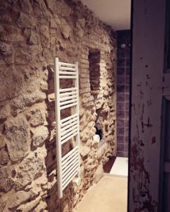 Cette chambre est dotée d'un mur en pierre avec un portant. dans l'établissement La Dolce Vita. Boutique Apartment, à Gérone