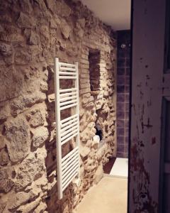 a room with a stone wall with a rack on it at La Dolce Vita. Boutique Apartment in Girona