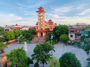 un grand bâtiment avec une tour d'horloge dans une ville dans l'établissement Viet Huong Hotel, à Ninh Binh