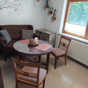 een woonkamer met een tafel en stoelen en een bank bij Beim Schlafwandler in Karlsbad