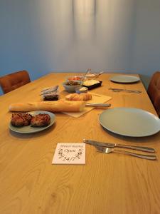 une table en bois avec des assiettes de nourriture dans l'établissement Santorini de durbuy, à Barvaux