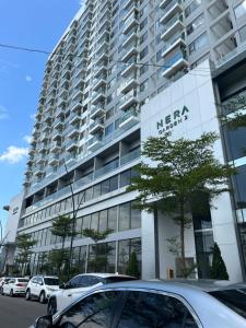 a large building with cars parked in front of it at Chi Homestay Nera Garden Huế in Hue
