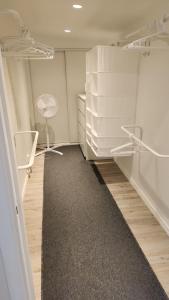 Habitación vacía con armarios blancos y alfombra. en Tift bossgård, en Linköping
