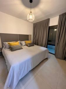 a bedroom with a large white bed with yellow pillows at COMPLEJO VICTORIO in San Luis