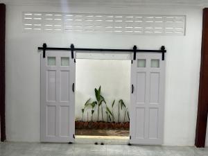 a white garage with two doors and a window at The Picnic House Battambang in Battambang