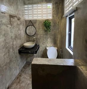 ein Bad mit einem Waschbecken, einem Spiegel und einem Fenster in der Unterkunft The Picnic House Battambang in Battambang