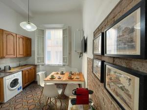 a kitchen with a table and a sink and a microwave at La Casa di Eli Appartamenti in Pisa