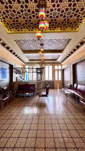een grote kamer met banken en stoelen en een plafond bij Sidi Mehrez HOTEL in Tunis