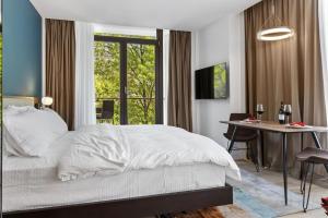 a bedroom with a bed and a desk and a window at Uni88 Apart Hotel in Bucharest