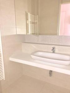 Baño blanco con lavabo y espejo en City Centre - Best location, big & new 110 m2 apt en Viena