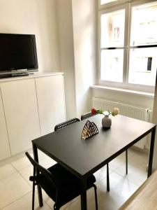 una mesa negra y sillas en una habitación con TV en City Centre - Best location, big & new 110 m2 apt en Viena