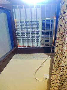 ein Zimmer mit einem Fenster, das mit einem Kabel verbunden ist in der Unterkunft Luxurious 3BHK Urban Retreat Homestay in Jaipur