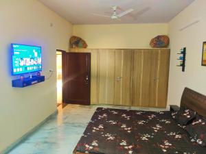 sala de estar con TV de pantalla plana en la pared en Luxurious 3BHK Urban Retreat Homestay, en Jaipur