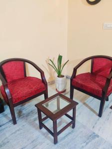 dwa krzesła i stolik kawowy w pokoju w obiekcie Luxurious 3BHK Urban Retreat Homestay w mieście Dżajpur