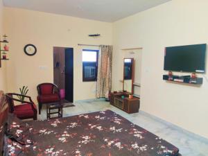 a living room with a bed and a flat screen tv at Luxurious 3BHK Urban Retreat Homestay in Jaipur