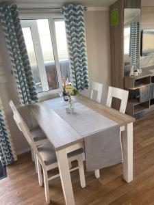 a dining room table and chairs in a room at 2 bedroom (sleeps 6) caravan to rent in allonby in Maryport