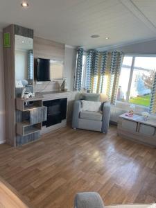 a large living room with a couch and a tv at 2 bedroom (sleeps 6) caravan to rent in allonby in Maryport