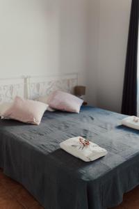 a bed with two pillows on it with a blue blanket at Casa Margarida in Albernoa +25 photos
