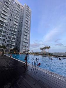 una persona caminando en una piscina al lado de un edificio en Chi Homestay Nera Garden Huế, en Hue