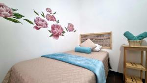 a bedroom with a bed with flowers on the wall at Central Hostel Reforma in Guatemala