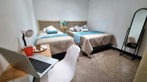 a room with two beds and a laptop on a desk at Central Hostel Reforma in Guatemala
