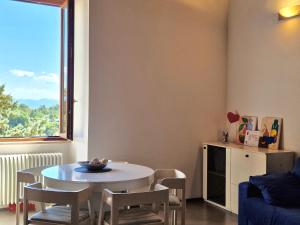 sala de estar con mesa, sillas y ventana en Casa Alferi by TraMonti Apartments, en LʼAquila
