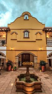 a large building with a fountain in front of it at Maria Bonita Hotel in Villa de Leyva