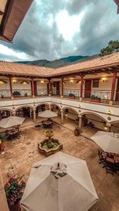 a courtyard with tables and umbrellas in a building at Maria Bonita Hotel in Villa de Leyva