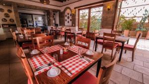 a restaurant with wooden tables and chairs in a room at Maria Bonita Hotel in Villa de Leyva