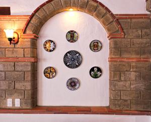 un arco con un grupo de placas en una pared en Maria Bonita Hotel, en Villa de Leyva