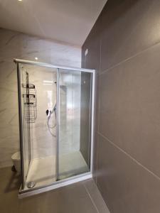 una ducha con puerta de cristal en un baño en Casa Alferi by TraMonti Apartments, en LʼAquila 45 fotos más