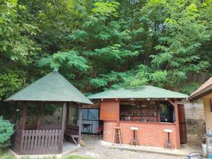 a small building with a gazebo with wine bottles at Mala Vikendica in Kruševac