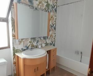 un baño con lavabo y espejo en Apartamento Huelva Centro, en Huelva