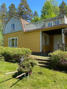Una casa amarilla con un árbol delante. en Mark Villan en Örebro