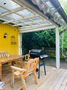 a grill on a deck with a table and chairs at Mark Villan in Örebro