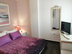 ein Schlafzimmer mit einem lila Bett und einem Spiegel in der Unterkunft Design Art Home in Zoödóchos