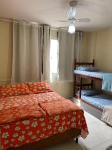 um quarto com 2 camas e uma ventoinha de tecto em Apartamento Cabo Frio - 2 quartos em Cabo Frio