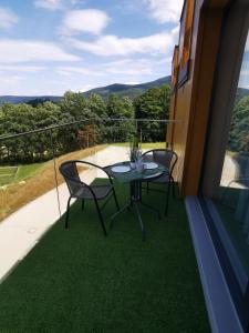 a patio with a table and chairs on a balcony at Apartament Apres Ski in Karpacz