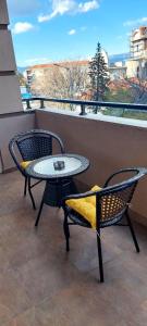 um pátio com 2 cadeiras, uma mesa e uma janela em Sandras Apartment em Strumica